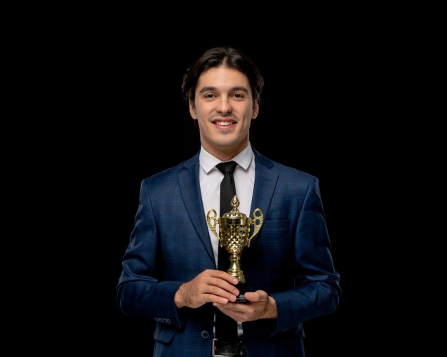 business-man-smart-handsome-guy-dark-blue-suit-with-tie-holding-golden-trophy_140725-161998